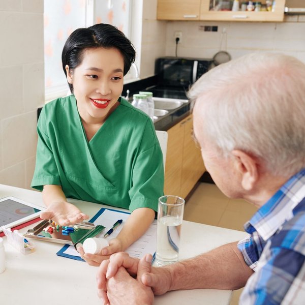 aide assisting a senior at home